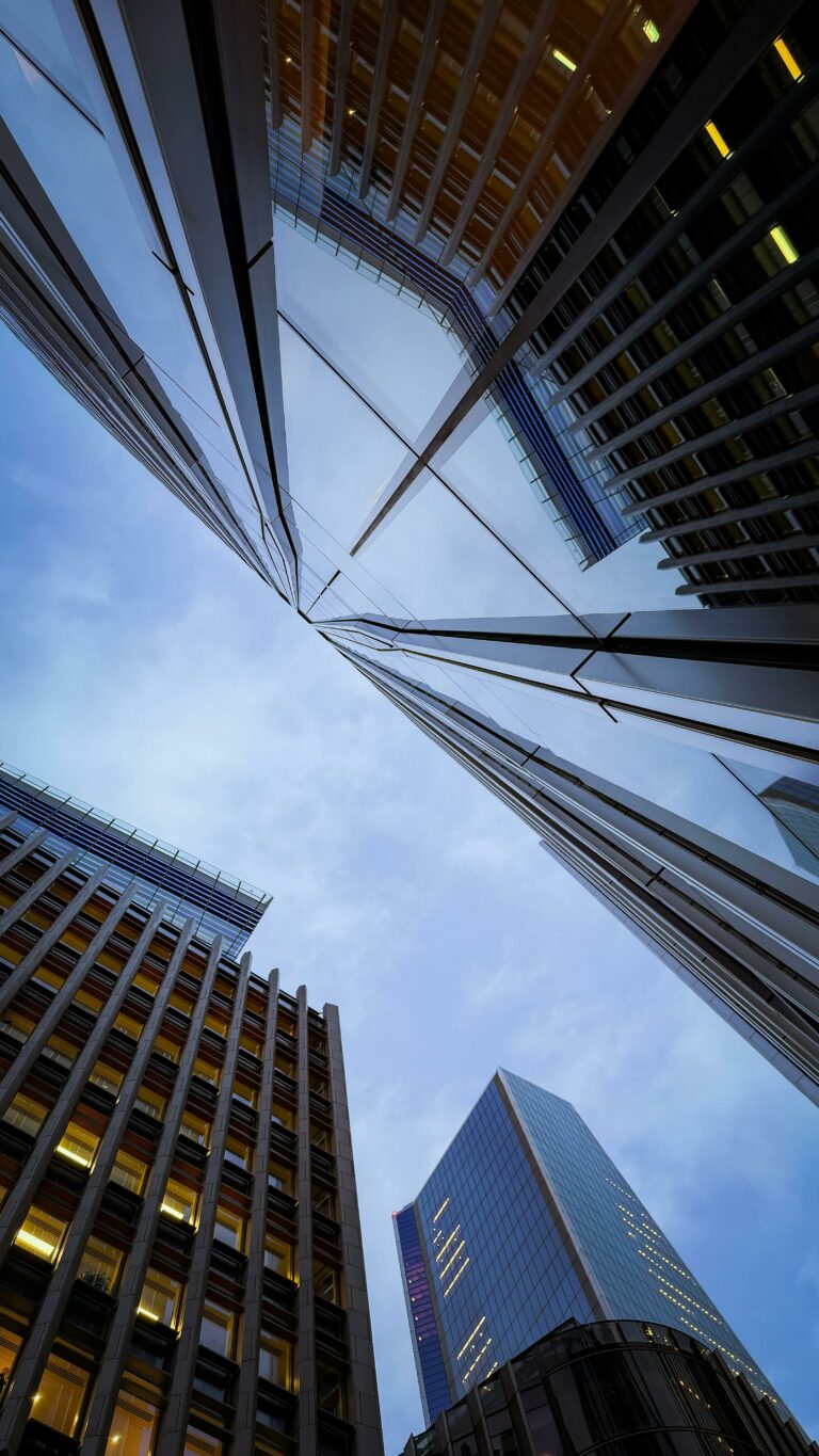 Dramatic view of London's skyscrapers reaching into the blue evening sky.
